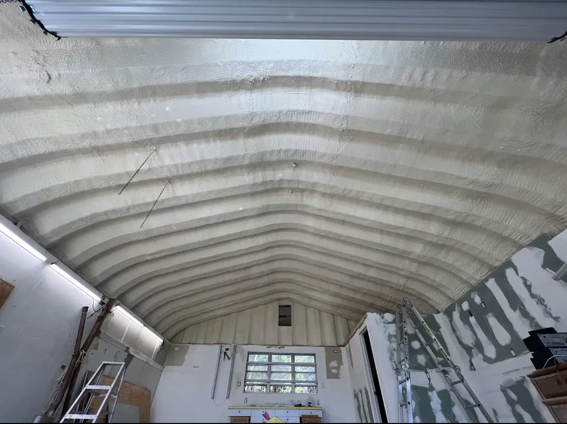 Spray polyurethane foam applied to the underside of a metal roof deck in Manor